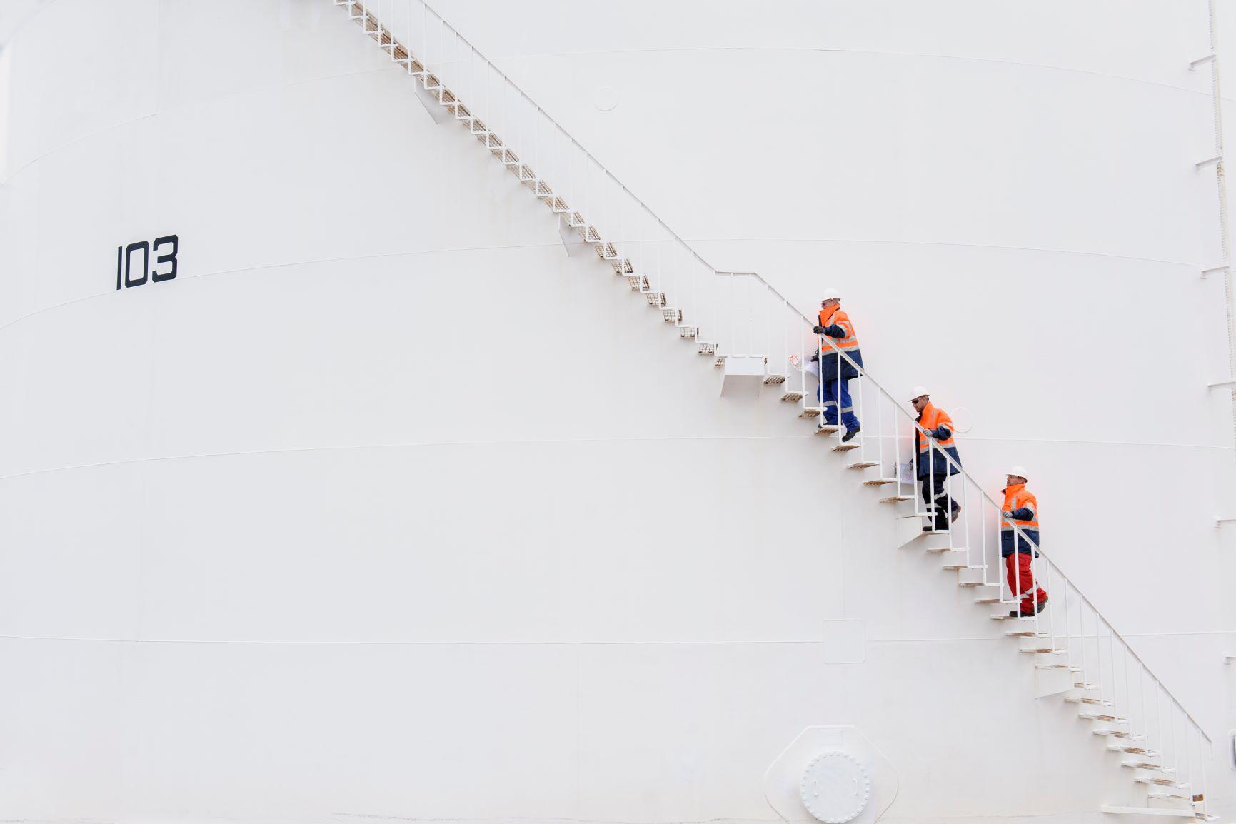 Techniciansclimbingfuelstoragetankstaircase